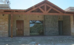 Construcciones Basti - Fachada de casa en ladrillo y piedra